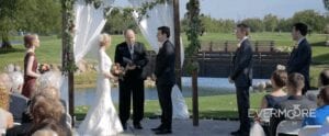 Lovely outdoor ceremony at local golf course, complete with flower garnished arbor | www.EvermooreFilms.com