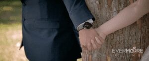 Bride and groom hold hands around a tree for a "blind" first look | www.EvermooreFilms.com